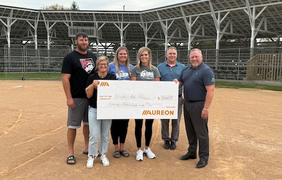 Image of the Breda Ballpark check presentationwith the ballpark in the background.
